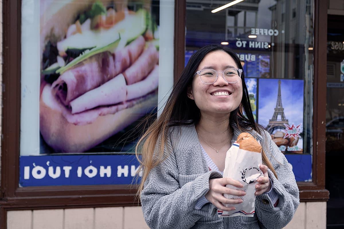 在多切斯特的一家商店前，一名学生拿着一个越南三明治.